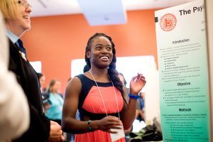 High school student Olive Tambou presents results from her diabetes study during a graduation ceremony for Science and Health Education Partnership (SEP) interns on Thursday, July 28, 2016, at UCSF's Mission Bay Campus. Listening at left is San Francisco Unified School District Board Member Jill Wynns..